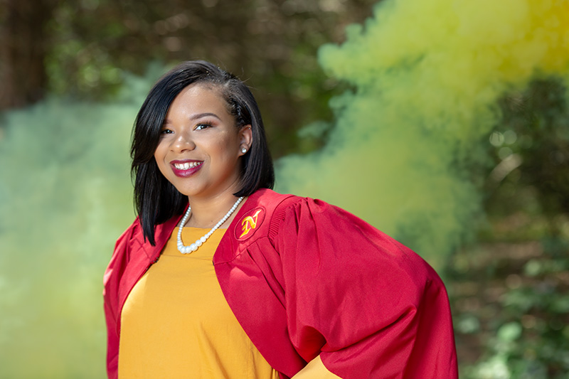 person smiling and posing in graduation outfit for graduation photography