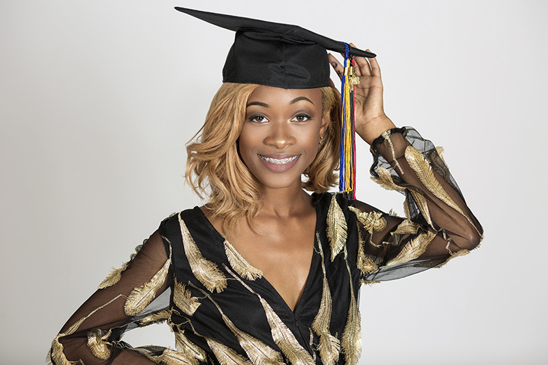 person holding graduation cap posing for senior portrait